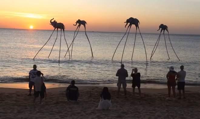 Des touristes contemplent le coucher du soleil sur Bai Truong, île de Phu Quôc. Photo : VNA.