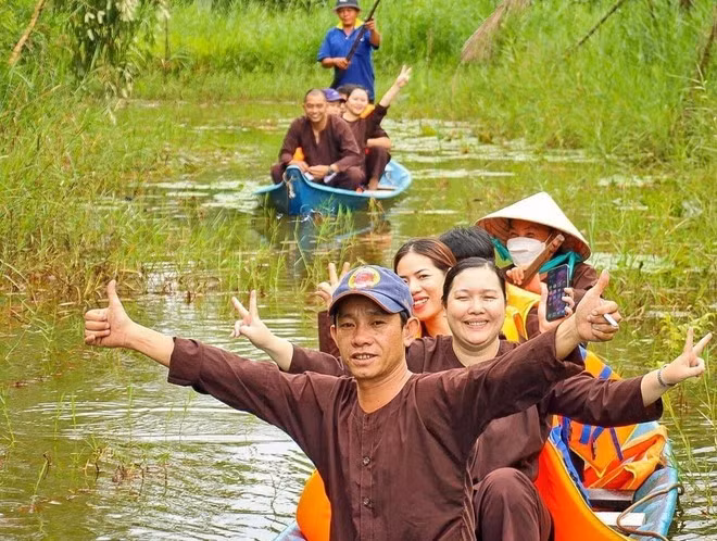 Les visiteurs apprécient les balades en pirogue à travers la forêt, au sein d’un site de tourisme écologique dans la région de la forêt d’U Minh Hạ. Photo: VNA.