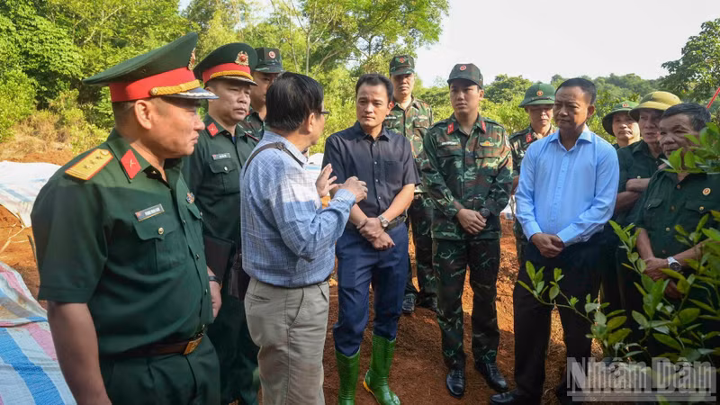 Le vice-président du Comité populaire de la province de Lao Cai, Giang Quoc Hung (en noir), et le colonel Luong Hoang Giang, commissaire politique du Commandement militaire provincial, étaient présents dès le matin pour échanger avec les anciens combattants et diriger les opérations d’exhumation des dépouilles des soldats morts pour la Patrie. (Photo : Cong Hai)