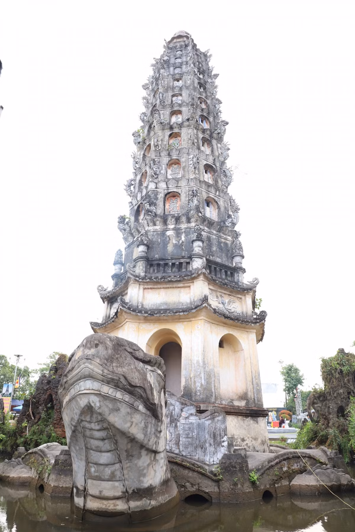 S’étendant sur près de 36 000 m², la pagode séduit d’abord par son imposante tour "Cuu pham Lien hoa", visible de loin. Édifiée en 1927, cette tour octogonale de 32 m de haut est composée de neuf niveaux superposés en forme de lotus, représentant les neuf cieux. Elle repose sur le dos d’une gigantesque tortue, tête tournée vers le sanctuaire, symbole de longévité et de stabilité. Au fond du tour, il y a un grand pilier de 98 marches de l'escalier en spiral. Photo : VOV