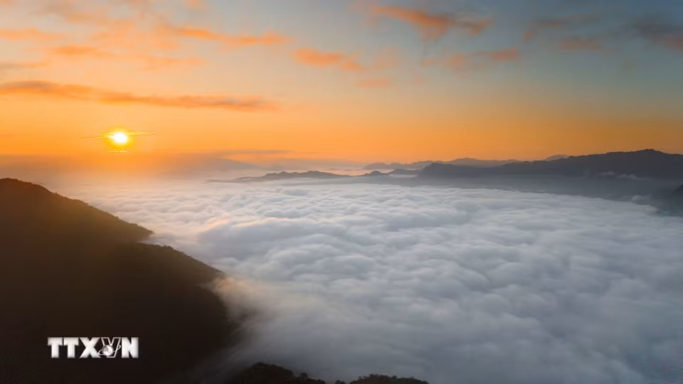 La lumière de l’aube teinte d’or les sommets qui émergent de la mer de nuages de Tang Quai. Photo : VNA
