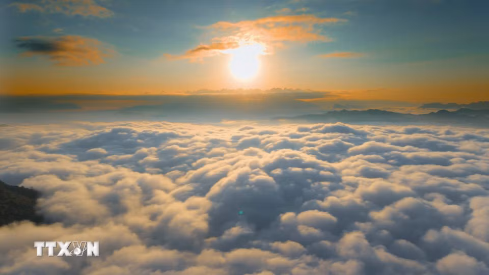 Les premières lueurs dorées de l’aube se répandent sur l’immense mer de nuages depuis le sommet du col de Tang Quai. Photo : VNA