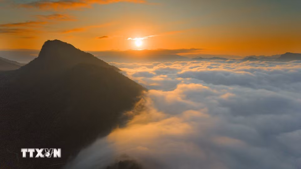 La lumière de l’aube dore les sommets et la mer de nuages du col de Tang Quai. Photo : VNA