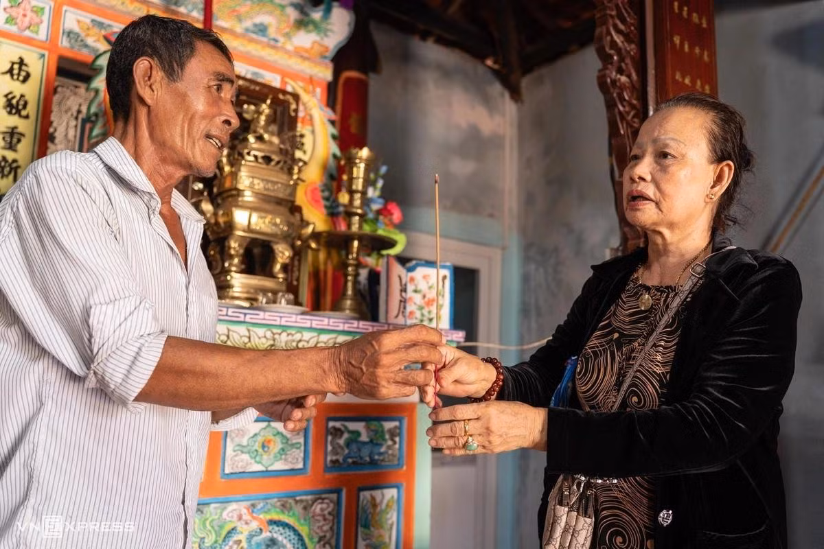 Pham Trai, 60 ans, gardien du temple de Tân, explique que, selon les documents conservés sur l’île, deux baleines se sont échouées sur le rivage au début du XIXe siècle. Après leur mort, les habitants ont organisé leurs funérailles, auxquelles ont participé de nombreux membres des communautés de pêcheurs. Photo : vnexpress.net