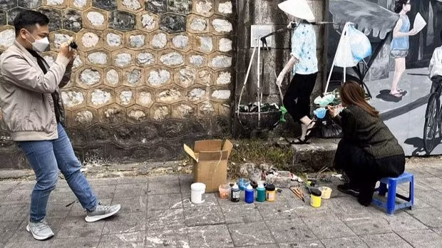 Une visiteuse veut participer au travail des artistes. Photo: CVN