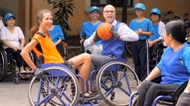 L'ambassadeur du Canada au Vietnam, Shawn Steil passe le ballon lors d'un match d'échange spécial entre les représentants des quatre pays du G4 avec des handicapés. Photo: extraire du clip