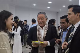Des délégués découvrent les produits d'entreprises cambodgiennes exposés lors du séminaire. Photo : VNA. 