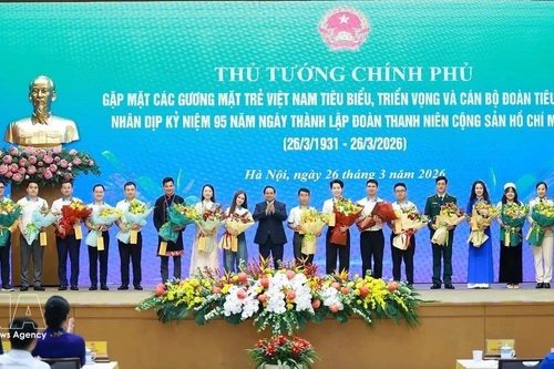 Le Premier ministre Pham Minh Chinh offre des fleurs de félicitations aux jeunes Vietnamiens exemplaires. Photo : VNA. 