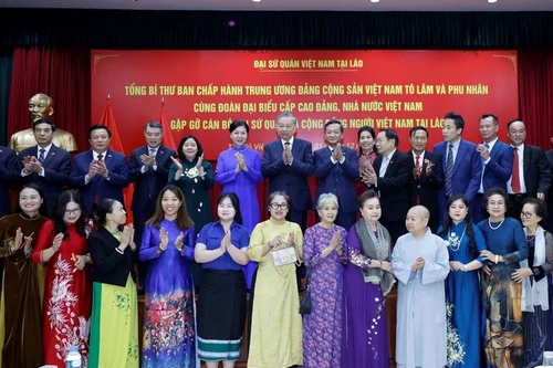 Le secrétaire général du PCV To Lam rencontre la communauté vietnamienne au Laos. Photo : VNA 