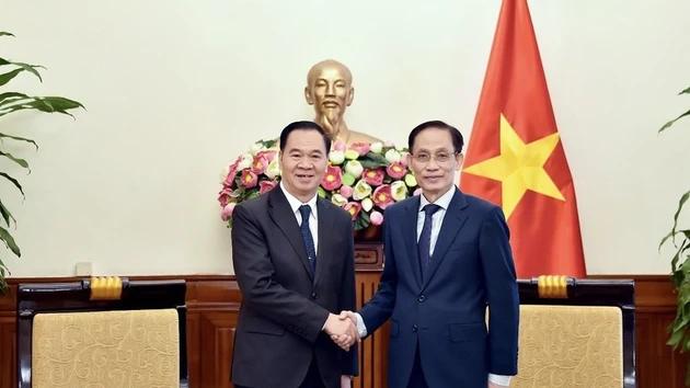 Le ministre vietnamien des Affaires étrangères, Le Hoai Trung (à droite) reçoit le ministre lao de l'Éducation et des Sports, Thongsalith Mangnomek. Photo : VNA. 