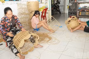 Mme Mai Thi Kim Phung et les membres de sa famille finalisent leurs produits artisanaux. 