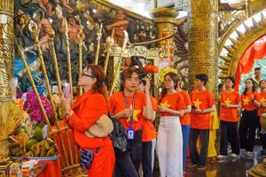 Des jeunes offrent de l'encens aux rois Hung au parc culturel et touristique Suoi Tien, à Hô Chi Minh-Ville. Photo : NDEL.