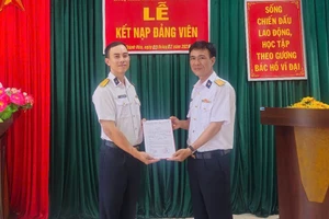 Le camarade Nguyen Thanh Hai (à gauche) reçoit sa décision officielle d’admission au PCV. Photo : QĐND.