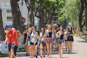 Des touristes étrangers sous un soleil ardent à Hanoi. Photo : VTC News.
