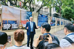 L'ambassadeur de France au Vietnam, Olivier Brochet, présente aux journalistes l'exposition photographique installée sur les murs de l'ambassade. Photo : CVN.