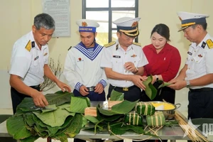 Les membres de la délégation, les cadres et les soldats participent à la préparation des banh chung. Photo : QĐND.
