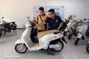 Un client se renseigne sur des motos électriques dans un magasin de motos à Cân Tho (au Sud du Vietnam). Photo : VNA.