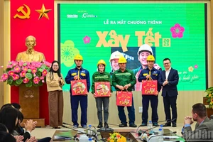 Les représentants de la direction du Nhân Dân et de la société Coteccons offrent des cadeaux aux ouvriers de Coteccons et de la SARL d’assainissement de Hanoï.