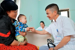 Le docteur Nguyen Duy Dong examine un petit patient au poste médical de Lung Cu.