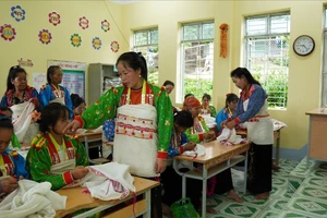 Des artisans initient les apprenants de la classe de confection de costumes traditionnels de l’ethnie Mang. Photo : baodantoc.