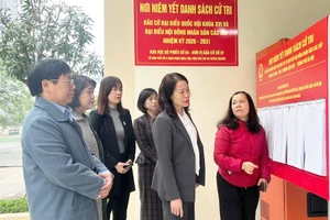 Les dirigeants du quartier de Cau Giay ont inspecté le travail d’affichage officiel ainsi que la préparation des infrastructures matérielles au sein du bureau de vote n°4. Photo : HNM