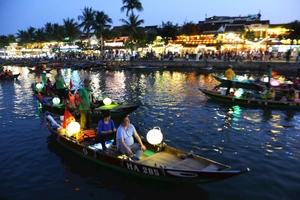 Un habitant taille des pots de fleurs décoratifs devant sa maison, se préparant à accueillir les visiteurs.
