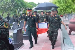 Les restes de soldats tombés pour la Patrie dont l’identité n’a pas encore été établie, au cimetière militaire de Mai Dich (quartier de Phu Dien), sont transportés par les cadres et soldats vers le site de prélèvement. (Photo : HUU THU)