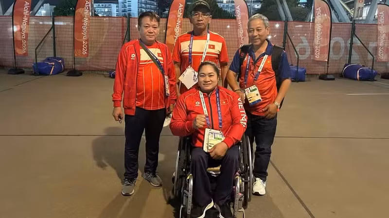 Nguyen Thi Ngoc Thuy aux côtés de son entraîneur et des représentants de la délégation. Photo : Comité paralympique du Vietnam