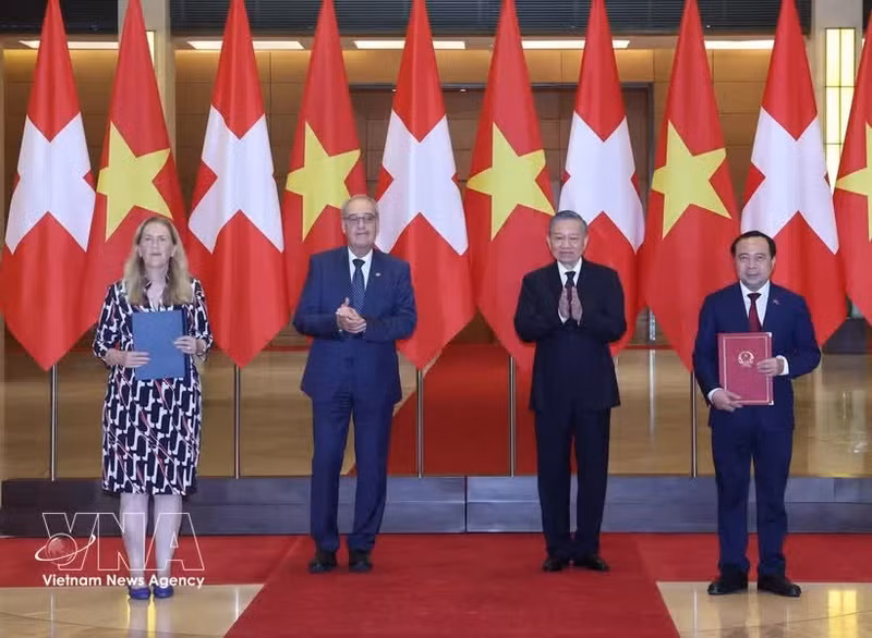 Le secrétaire général du Parti et président de la République, To Lam, et le président de suisse, Guy Parmelin assistent à la cérémonie de remise des documents de coopération entre les deux pays. Photo : VNA.