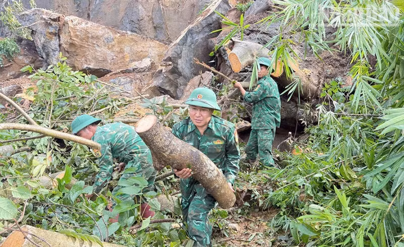 Des cadres et soldats du poste-frontière de Chieng Tuong déblayent des arbres, de la terre et des pierres tombés sur la route dans la commune de Lóng Phiêng. (Photo : Quang Hung)