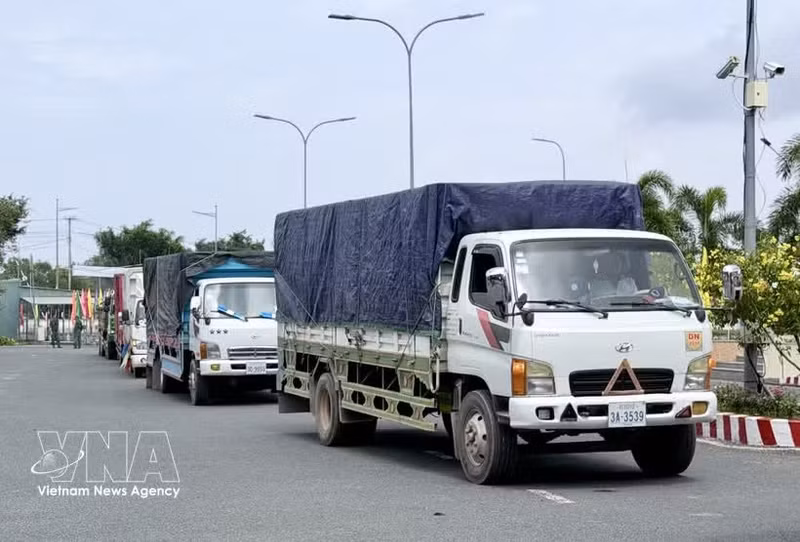 Des camions de marchandises attendent d’effectuer les formalités d’importation au poste-frontière international routier de Khanh Binh. Photo : VNA.