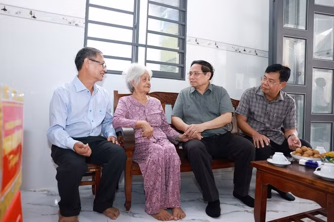 Le Premier ministre Pham Minh Chinh (deuxième à partir de la droite) rend visite à Nguyen Thi Co (deuxième à partir de la gauche), 85 ans, une contributrice révolutionnaire de la commune de Binh My, province d’An Giang, le 20 juillet. Photo : VNA