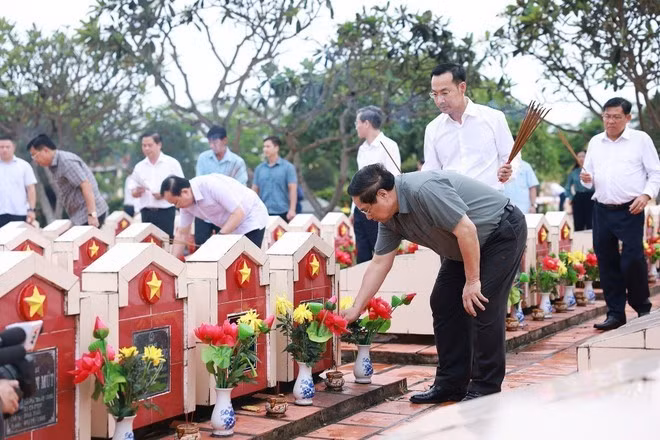 Le Premier ministre Pham Minh Chinh et des responsables offrent de l’encens sur les tombes des martyrs au cimetière des martyrs d’An Giang, le 20 juillet. Photo : VNA.