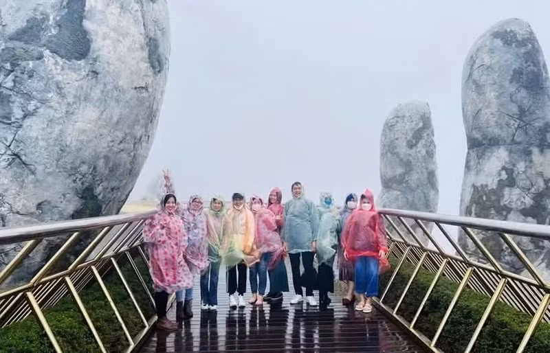 Des touristes découvrent la saison des pluies à Dà Nang. Photo : hanoimoi.vn