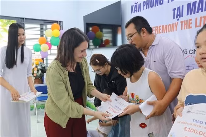 Un représentant de l’organisation Enfants d’Asie remet un soutien financier et des cadeaux de la Fête de la mi-automne aux enfants en situation difficile lors de la cérémonie. Photo : VNA