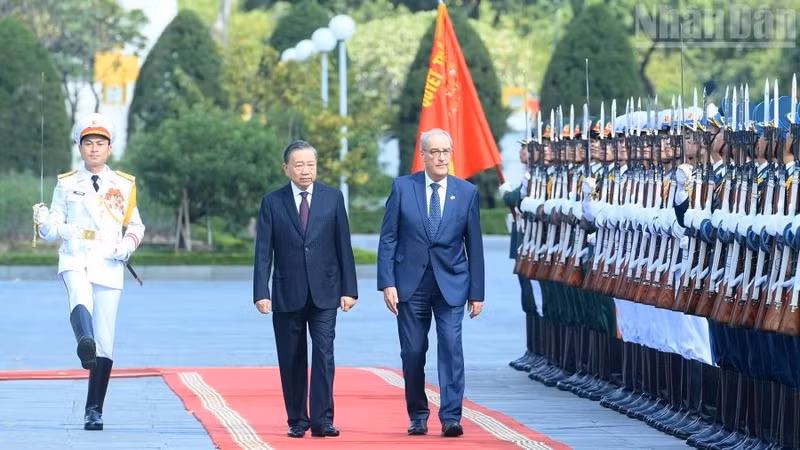 Les deux dirigeants vietnamien et suisse passent en revue la garde d'honneur de l'Armée populaire du Vietnam. Photo : VNA.