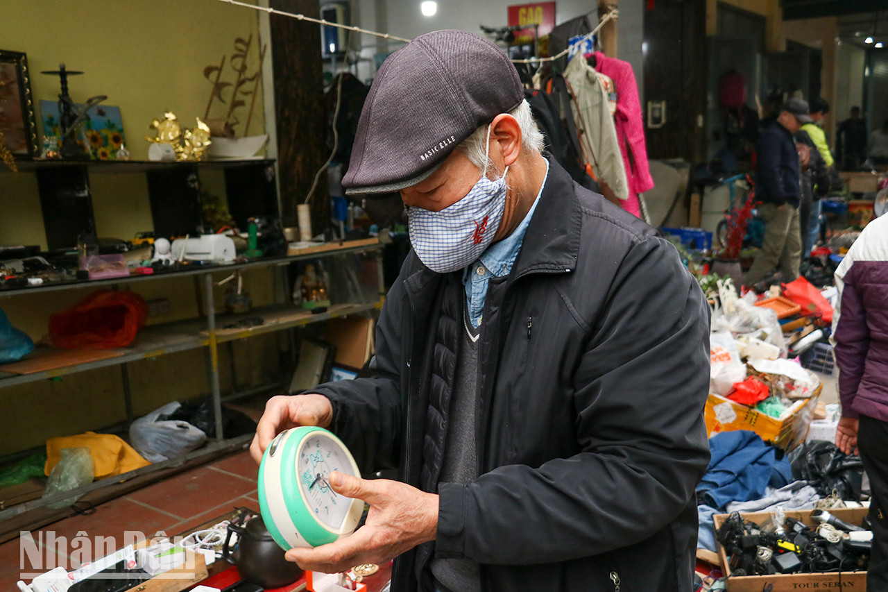 Un vieil homme choisit une montre d’occasion. Si les clients veulent acheter de bons articles d’occasion, ils doivent les choisir avec soin. Un vieil homme choisit une montre d’occasion. Si les clients veulent acheter de bons articles d’occasion, ils doivent les choisir avec soin.