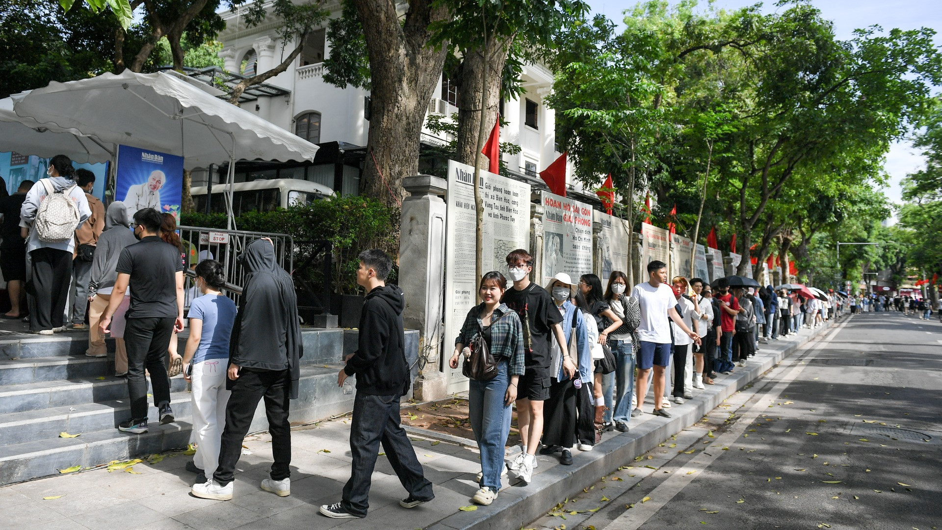 De nombreux jeunes font patiemment la queue pour recevoir le supplément spécial du Journal Nhân Dân