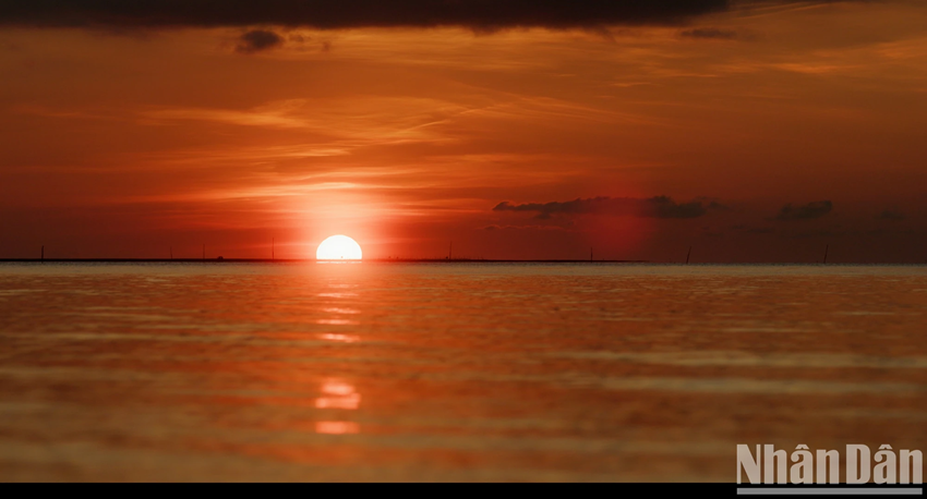 La surface de la mer scintille de reflets roses et orangés, miroir éclatant des couleurs vives du ciel, composant un paysage féerique que nul témoin ne pourrait jamais oublier. Photo : Nhân Dân. La surface de la mer scintille de reflets roses et orangés, miroir éclatant des couleurs vives du ciel, composant un paysage féerique que nul témoin ne pourrait jamais oublier. Photo : Nhân Dân.