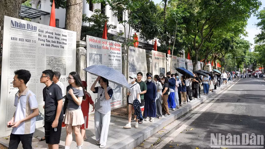Un grand nombre de lecteurs font la queue pour recevoir le supplément. Photo : Nhân Dân.