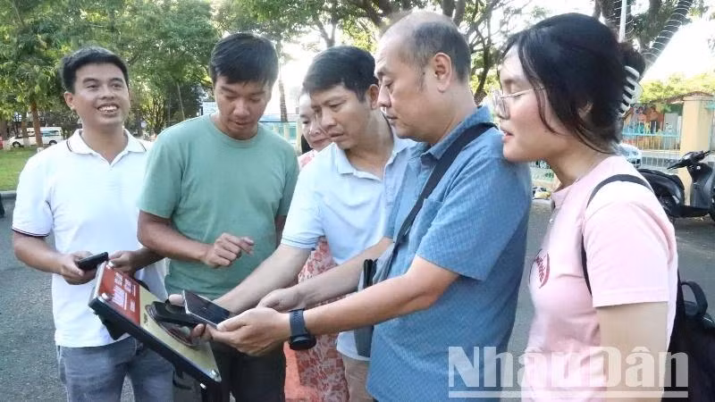 Les visiteurs sont ravis de découvrir l’expérience du scan des panneaux équipés de puces NFC dans le cadre du projet "Yêu lắm Việt Nam" au musée de Dak Lak. Photo : NDEL.