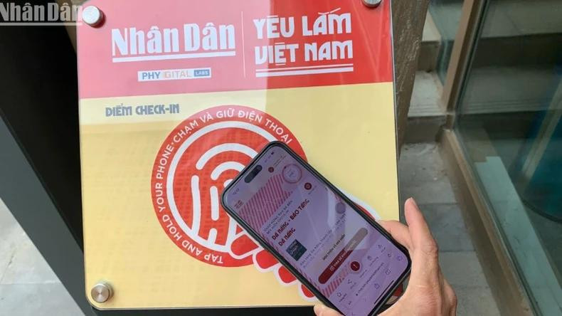 Les touristes scannent un panneau équipé de puces NFC au Musée de Da Nang. Photo : NDEL.