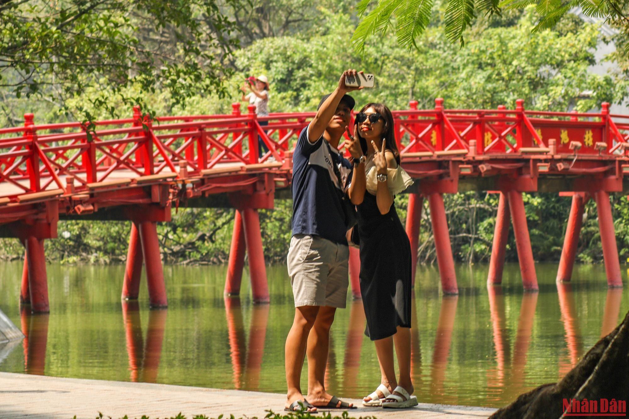 Les touristes prennent des photos et immortalisent les plus beaux moments de la capitale Hanoï.