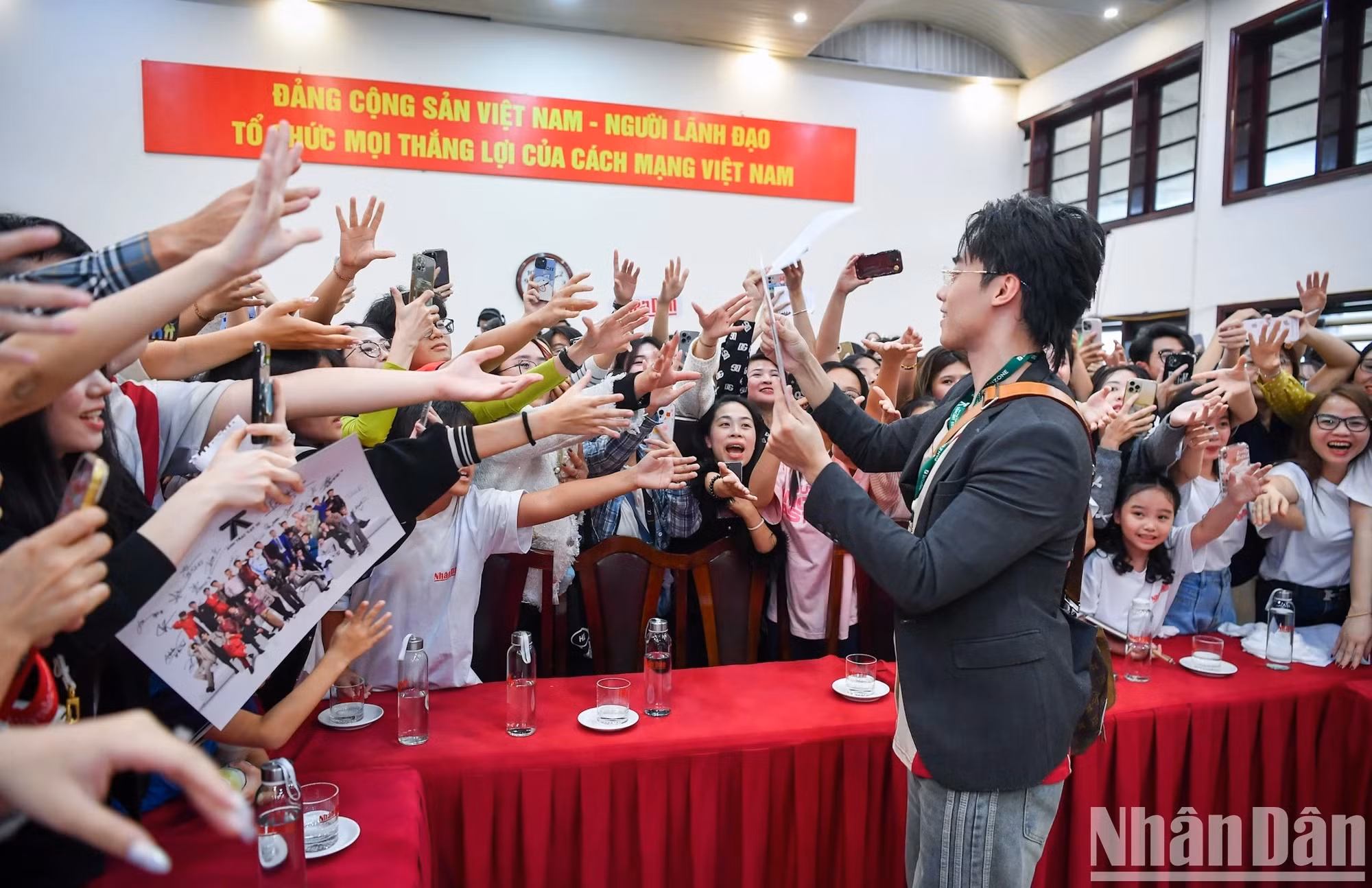 Les artistes interagissent avec des lecteurs du journal Nhân Dân.