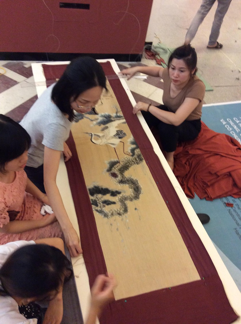 Le tableau brodé représentant des pins et des grues, soigneusement encadré par le personnel du Musée Hô Chi Minh pour être exposé le 18 mai 2017. Photo : baophapluat.vn