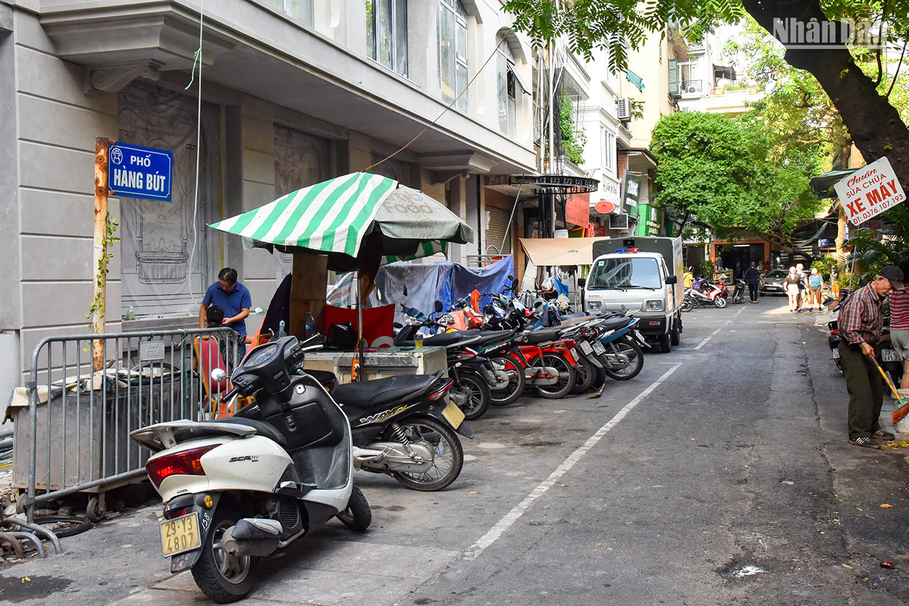 La rue Hàng But mesure 68 m de long et traverse les rues Thuôc Bac et Bat Su. Auparavant, elle appartenait au village de Dông Thanh, canton de Tiên Tuc, ancien district de Tho Xuong. Maintenant, elle fait partie du quartier de Hàng Bô (arrondissement de Hoàn Kiêm). Pendant la période coloniale française, cette rue s’appelait la rue Combanère, en 1945, son nom a été changé en Hàng But (Pinceaux). Dans le passé, la rue Hàng But s’appelait Hàng Mun, car elle se spécialisait dans la vente des morceaux de tissu pour les tailleurs afin de coudre des vêtements, des chapeaux, des chaussettes et des sacs-amulettes que les enfants portent lors de la fête de la mi-automne et du Têt Doan Ngo survenant le 5e jour du 5e mois lunaire. Elle développe aujourd’hui un commerce animé de biens de consommation et de services. La rue Hàng But mesure 68 m de long et traverse les rues Thuôc Bac et Bat Su. Auparavant, elle appartenait au village de Dông Thanh, canton de Tiên Tuc, ancien district de Tho Xuong. Maintenant, elle fait partie du quartier de Hàng Bô (arrondissement de Hoàn Kiêm). Pendant la période coloniale française, cette rue s’appelait la rue Combanère, en 1945, son nom a été changé en Hàng But (Pinceaux). Dans le passé, la rue Hàng But s’appelait Hàng Mun, car elle se spécialisait dans la vente des morceaux de tissu pour les tailleurs afin de coudre des vêtements, des chapeaux, des chaussettes et des sacs-amulettes que les enfants portent lors de la fête de la mi-automne et du Têt Doan Ngo survenant le 5e jour du 5e mois lunaire. Elle développe aujourd’hui un commerce animé de biens de consommation et de services.