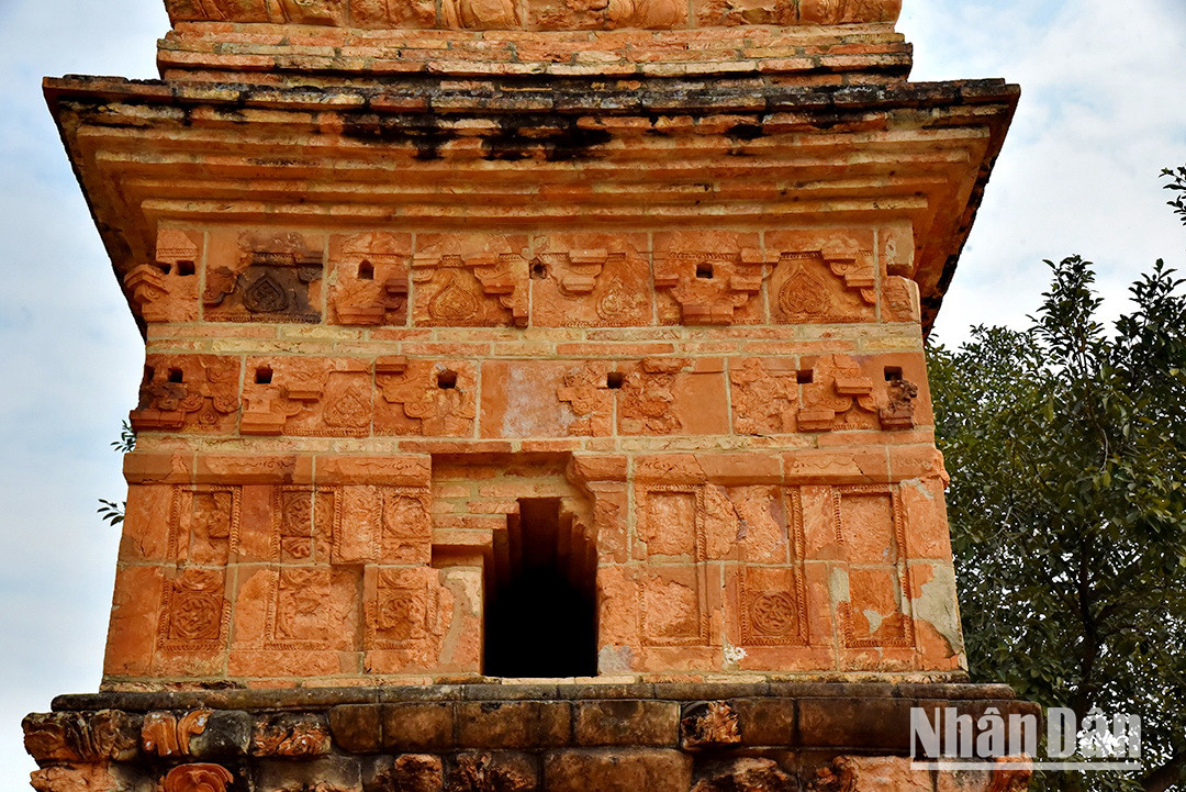 À l’extérieur, la tour Binh Son est entourée d’une couche de briques carrées, chaque côté mesure 0,46 m de long, couvrant tout le corps de la tour. L’extérieur de ces tuiles est décoré de riches motifs, tels que des fleurs de citronnier, des feuilles de Bodhi, des lions jouant avec une balle, des dragons, etc. Certaines tuiles sont gravées d’un seul motif décoratif, tandis que d’autres sont constituées de 2 ou 4 tuiles assemblées. Les lignes décoratives de la tour sont exquises et généreuses, sa forme est forte et pleine de vitalité de l’art national de la période prospère et puissante d’autonomie féodale des dynasties Ly-Tran (XIIe - XIIIe siècles). Photo : Phan Anh/NDEL. À l’extérieur, la tour Binh Son est entourée d’une couche de briques carrées, chaque côté mesure 0,46 m de long, couvrant tout le corps de la tour. L’extérieur de ces tuiles est décoré de riches motifs, tels que des fleurs de citronnier, des feuilles de Bodhi, des lions jouant avec une balle, des dragons, etc. Certaines tuiles sont gravées d’un seul motif décoratif, tandis que d’autres sont constituées de 2 ou 4 tuiles assemblées. Les lignes décoratives de la tour sont exquises et généreuses, sa forme est forte et pleine de vitalité de l’art national de la période prospère et puissante d’autonomie féodale des dynasties Ly-Tran (XIIe - XIIIe siècles). Photo : Phan Anh/NDEL.