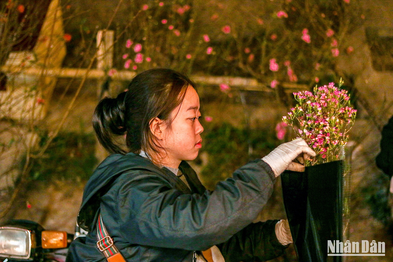 Une vendeuse emballe des fleurs avant de les donner aux clients. Une vendeuse emballe des fleurs avant de les donner aux clients.