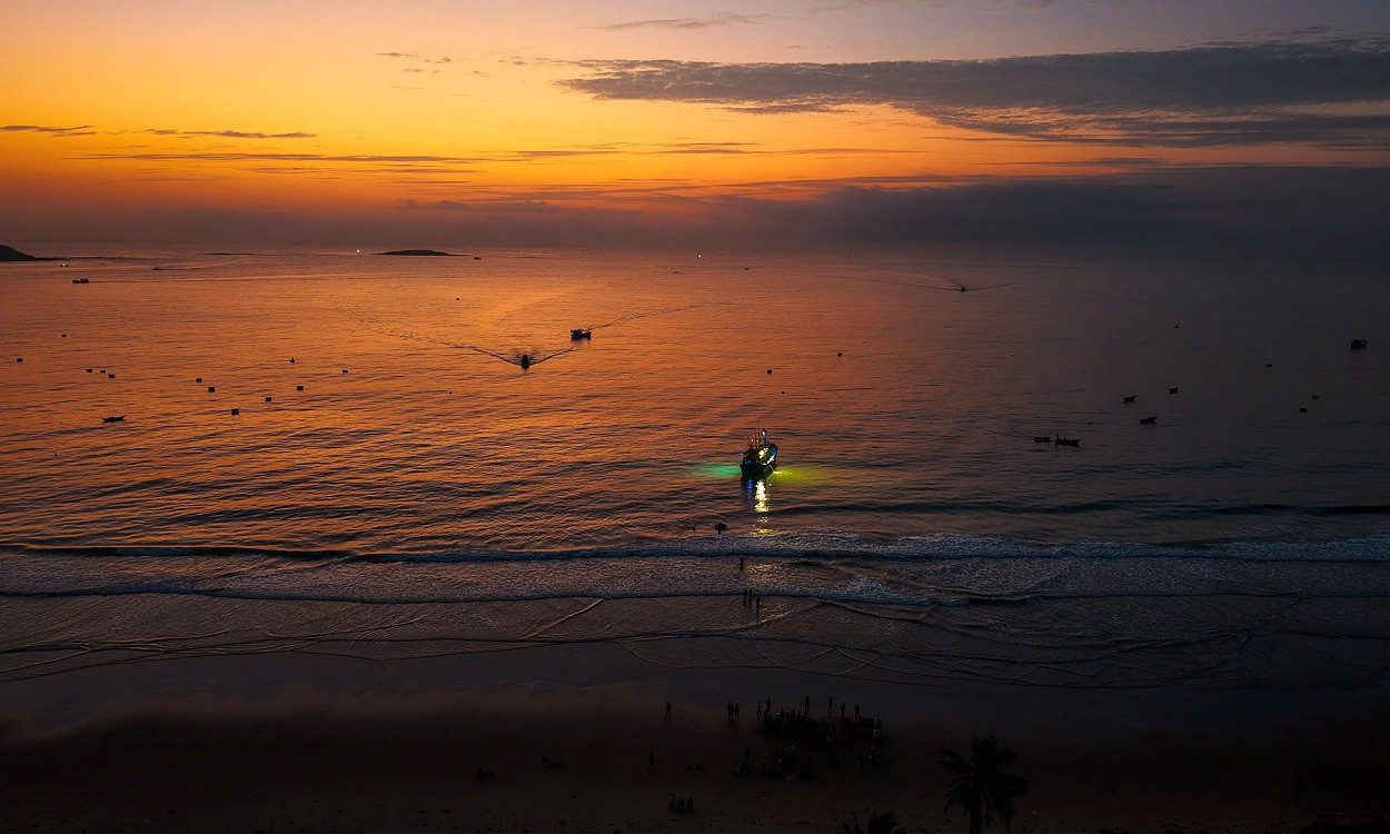 On voit le village de Long Thuy à l’aube, avec au loin les bateaux de pêche nocturne qui rentrent au port de pêche. Photo : Vnexpress. On voit le village de Long Thuy à l’aube, avec au loin les bateaux de pêche nocturne qui rentrent au port de pêche. Photo : Vnexpress.