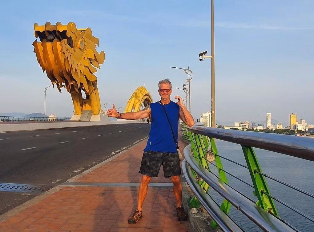 Grant Wilson pose près du pont du Dragon à Da Nang en mai 2025. Photo : Vnexpress.